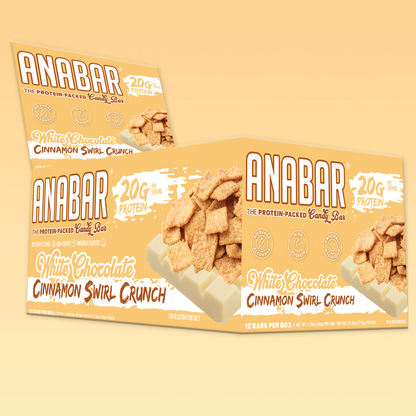 A box of The Anabar protein bars is open, highlighting the tempting Cinnamon Swirl Crunch flavor. Each bar offers 20G of protein and features a white chocolate coating with images of cinnamon cereal pieces on the packaging.