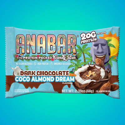 A The Anabar Coco Almond Dream protein bar wrapper features a tropical vibe with palm trees, a stone tiki statue, and a broken chocolate bar revealing coconut and almonds. "20g protein" and "Dark Chocolate Coco Almond Dream" are prominently displayed.