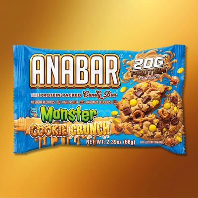 A blue milk chocolate package of The Anabar Monster Cookie Crunch protein bar features images of the bar with colorful candies and chocolate chips, highlights “High-Protein,” “No Sugar Alcohols,” and 20g protein per serving.